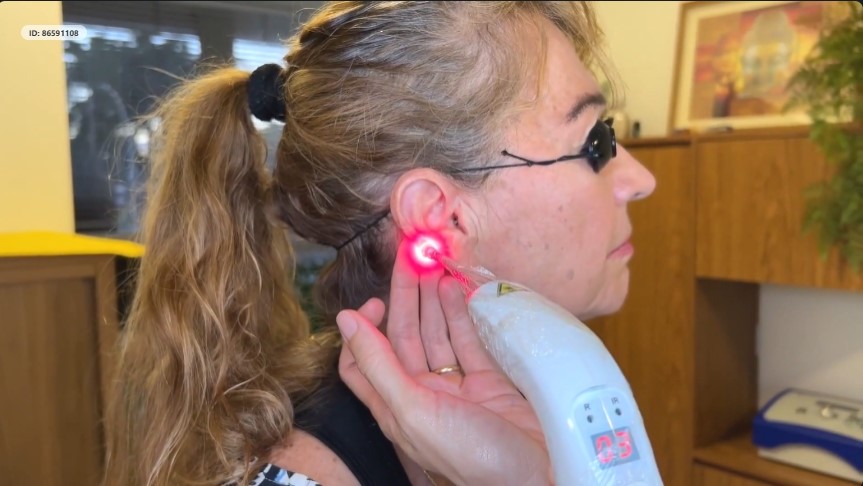 Profissional aplicando laserterapia em paciente